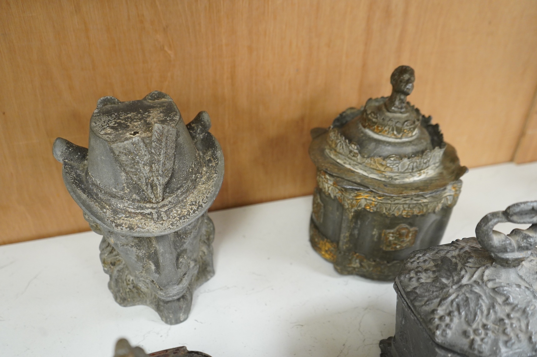 A collection of ten early 19th century lead tobacco boxes, one in the form of a goat’s head, tallest 20cm
